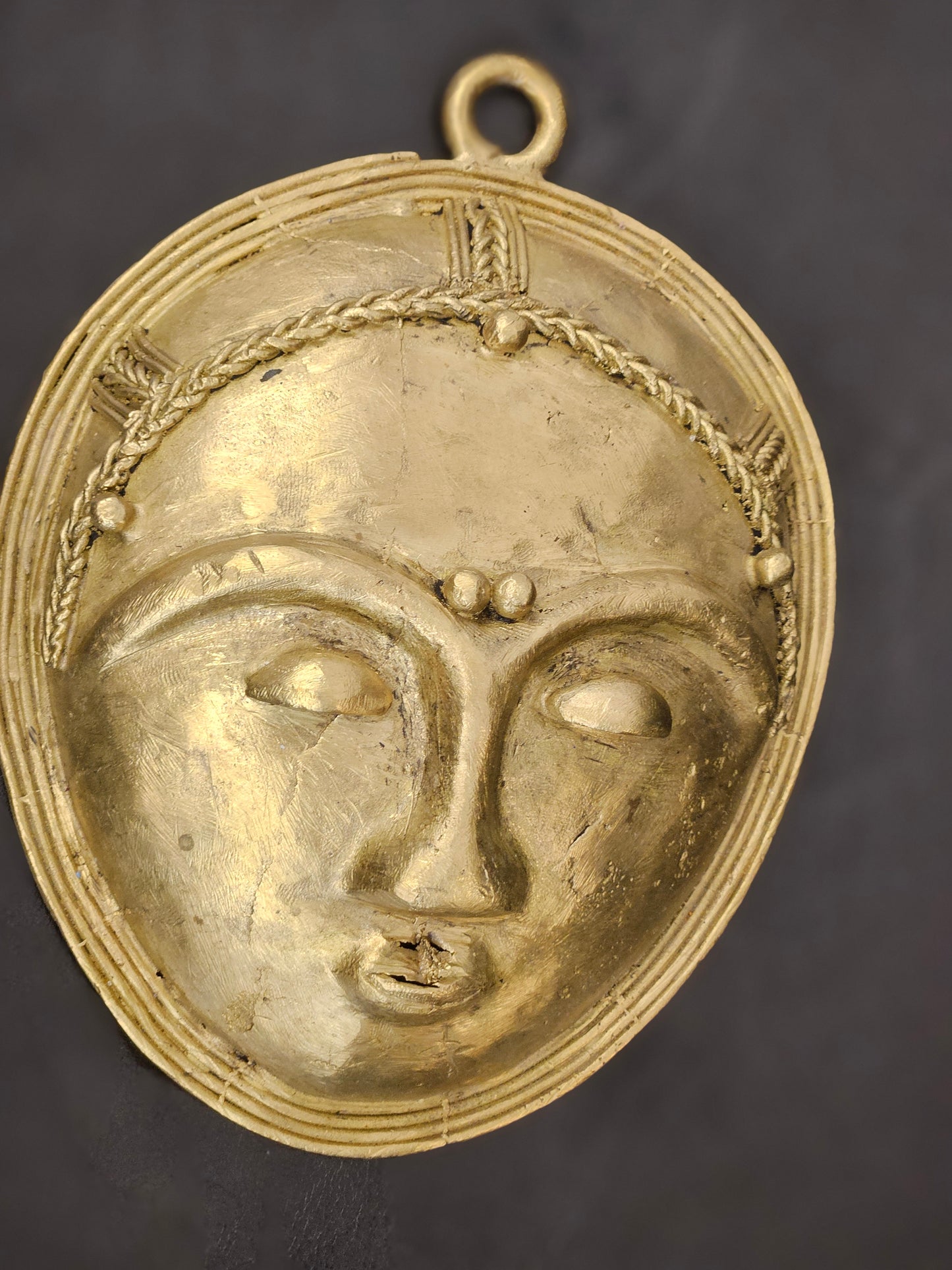 Close-up of detailed handmade brass tribal mask from Africa, 4.5 x 6 inches, cultural wall decor
